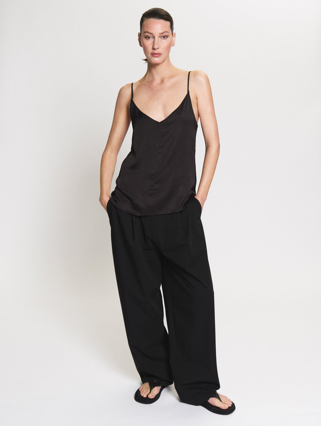Model wearing the satin Camisole in black and Pleated pants in black