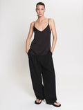 Model wearing the satin Camisole in black and Pleated pants in black