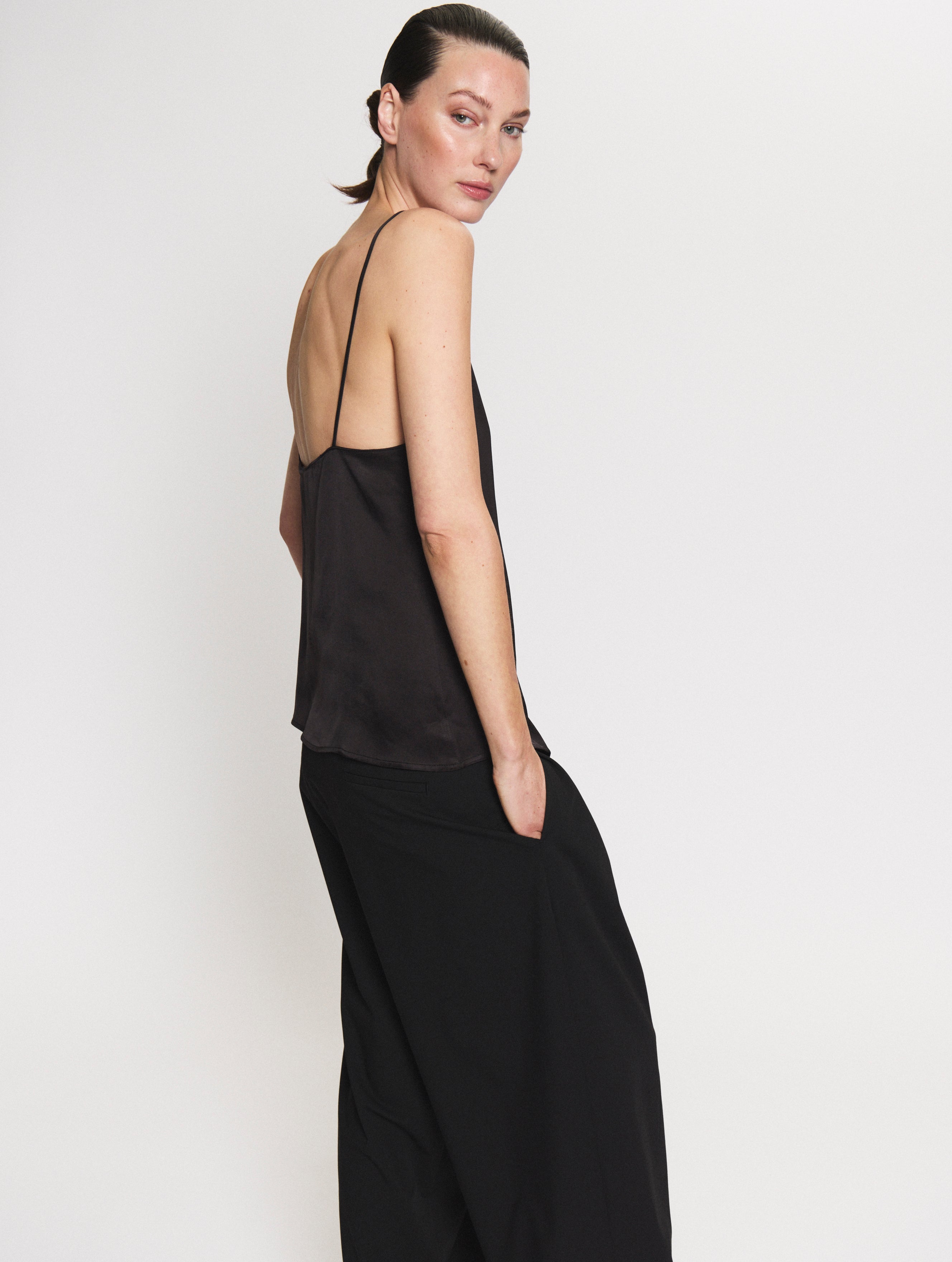 Side view of the satin Camisole in black and Pleated pants in black 