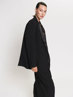 Side view of model wearing the Smoking blazer and Pleated pants in black 