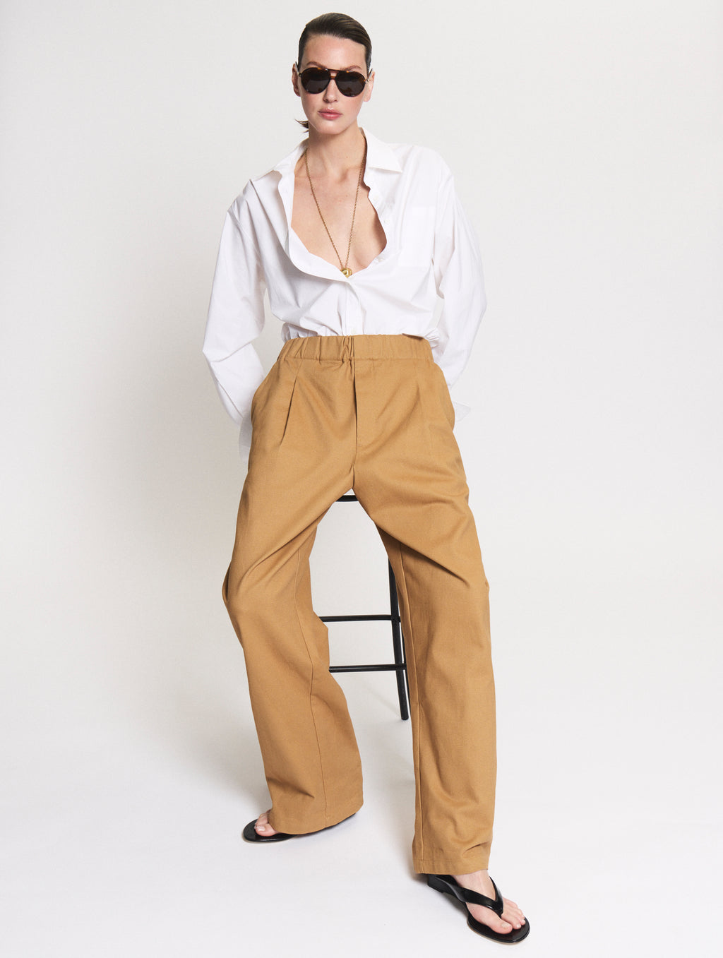 Model wearing a Body shirt in white together with the Utility pants in camel. 