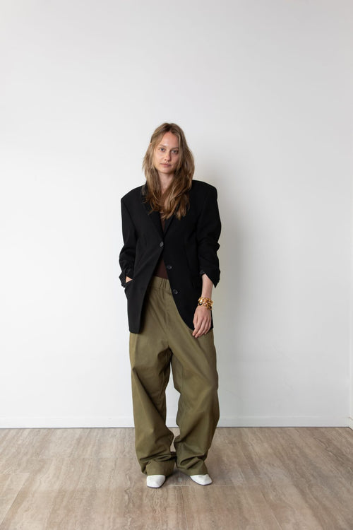 Model wearing the Original blazer in black and the Utility pants in Olive