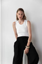 Detail of model wearing the Tanktop body in white and the Pleated pants in black