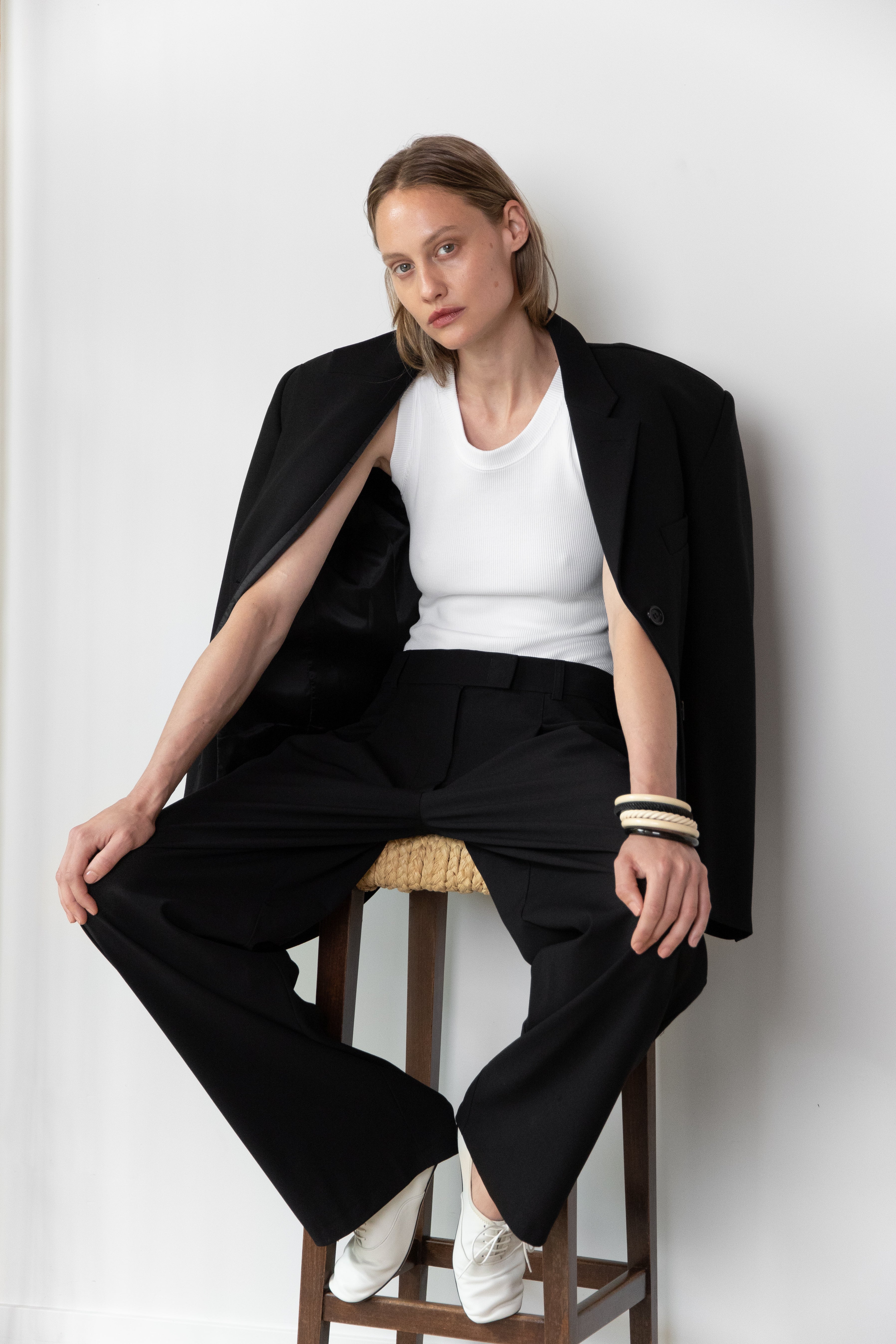 Model wearing the Tanktop body in white and the Pleated pants in black together with the original Blazer in black 