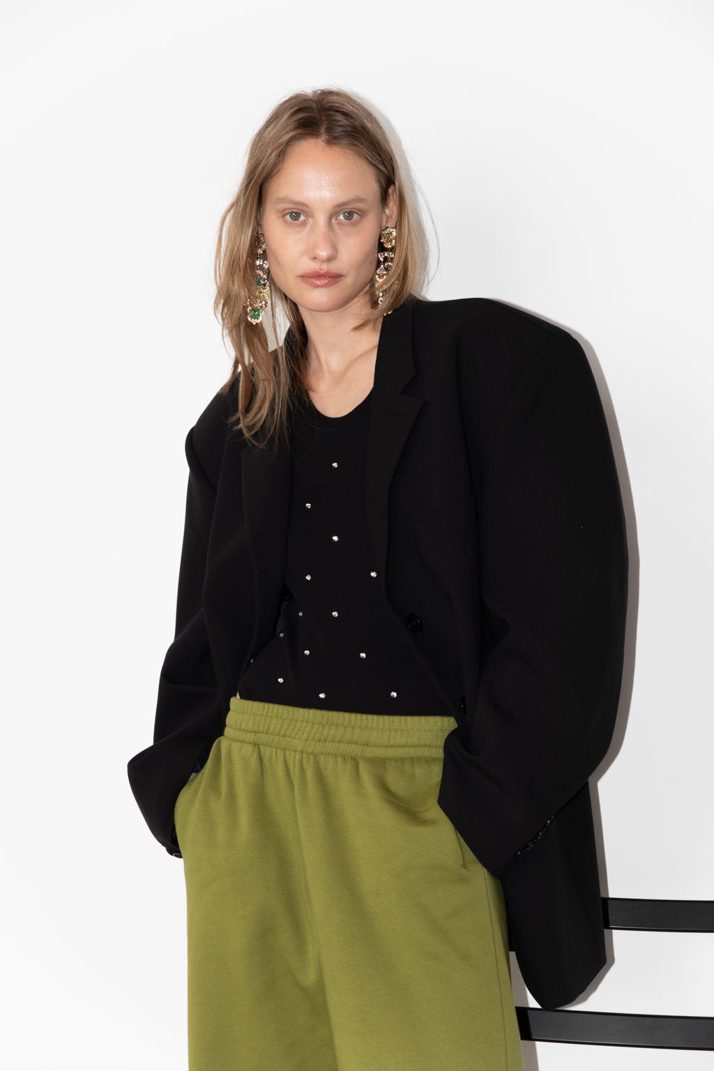 Model wearing The Love Stories x DYO Rhinestones tanktop body in black.  combined with The Blazer and Jogger in pear. 