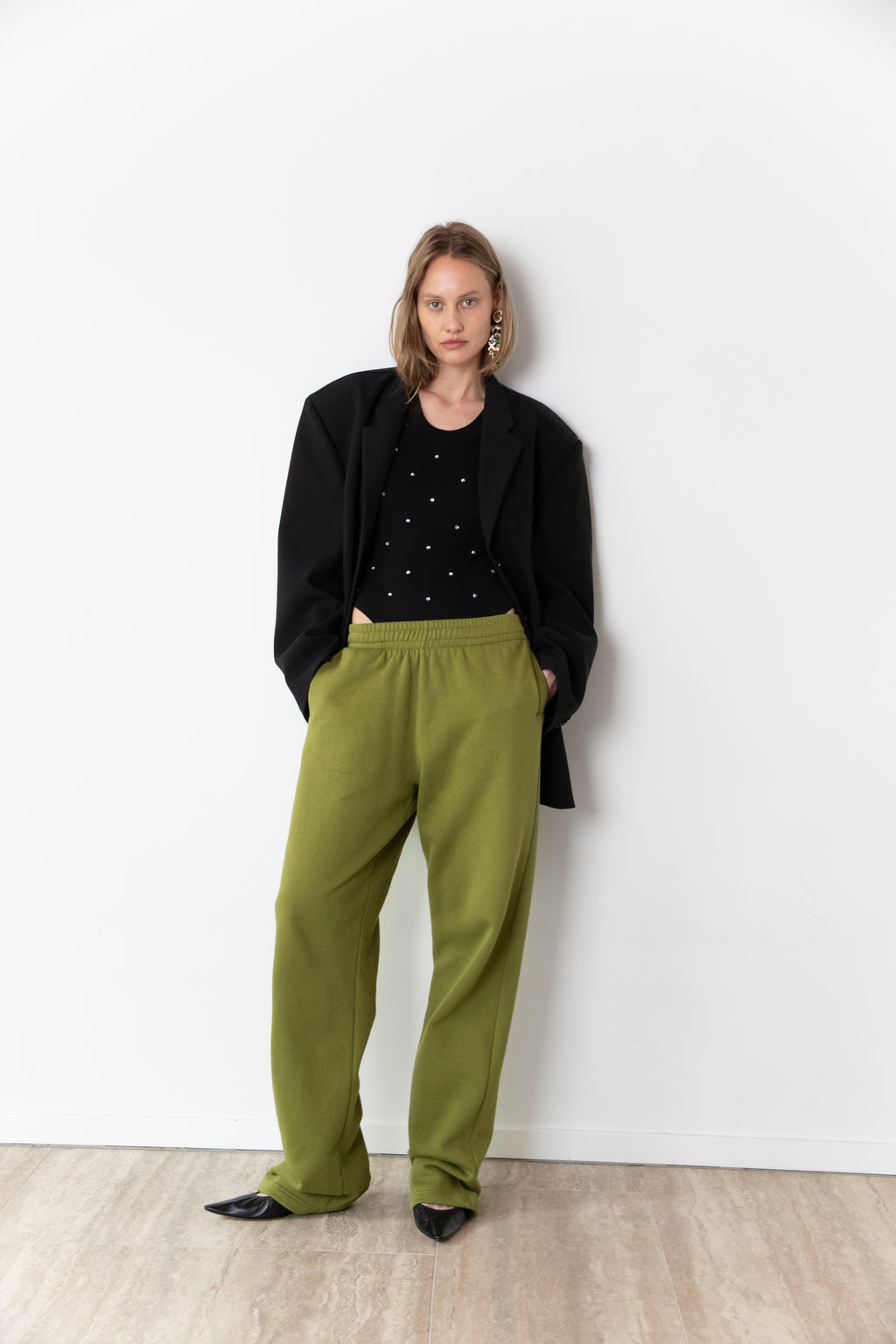 Total look of model wearing The Love Stories x DYO Rhinestones tanktop body in black.  combined with The Blazer and Jogger in pear. 