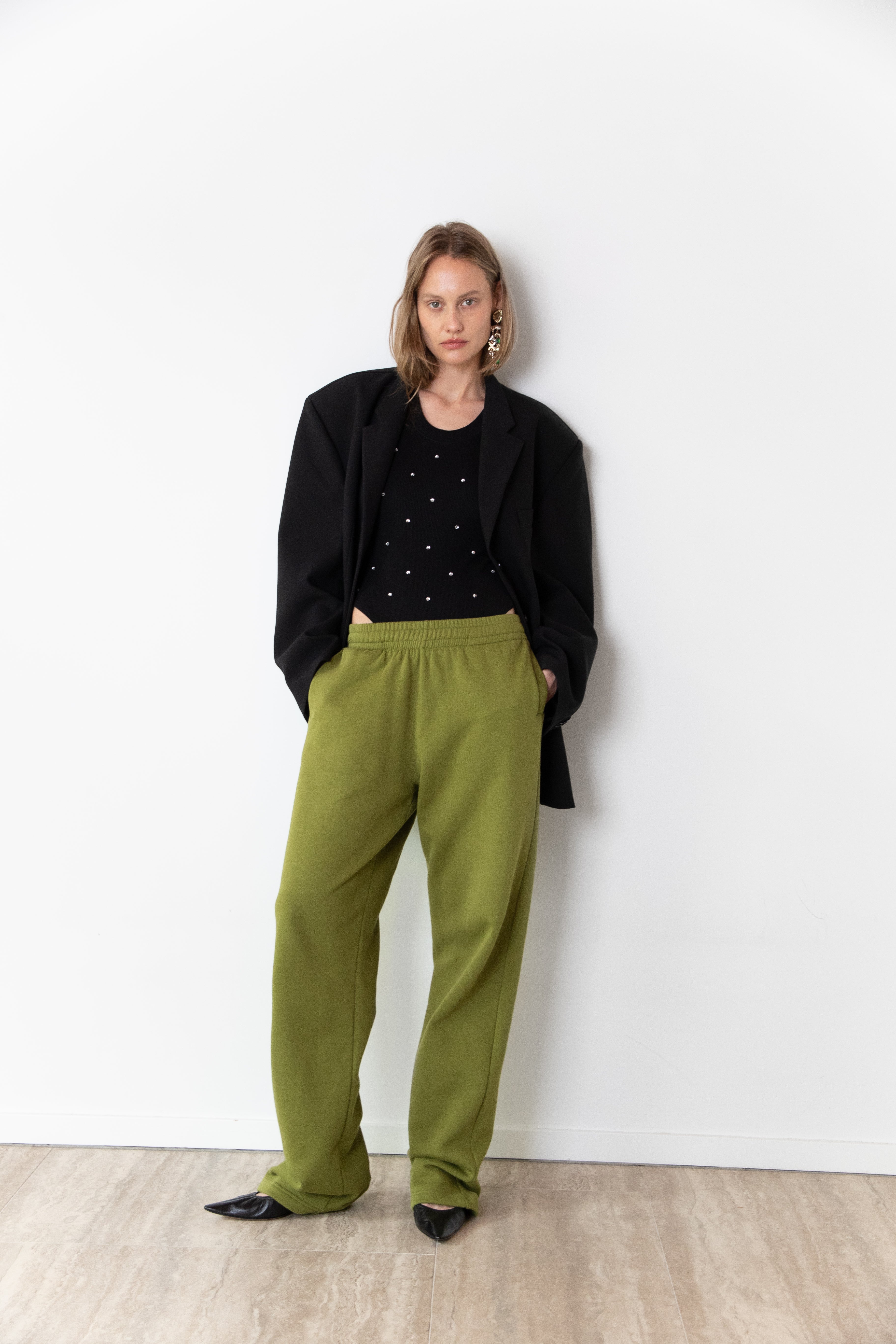 Total look of model wearing The Love Stories x DYO Rhinestones tanktop body in black.  combined with The Blazer and Jogger in pear. 