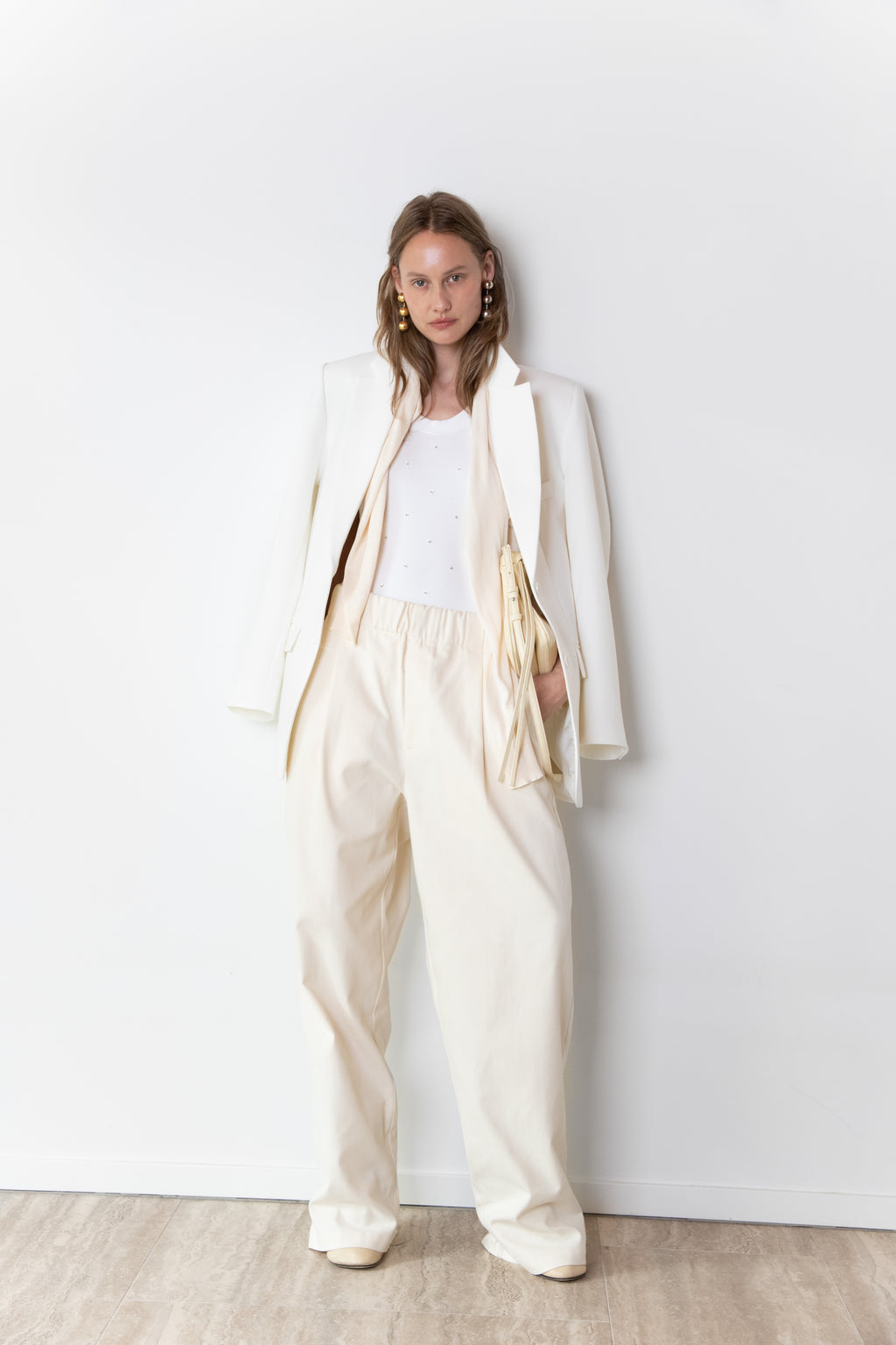 Total look of model wearing The Love Stories x DYO Rhinestones tanktop body in white  combined with The Blazer in Off White and The Utility pants